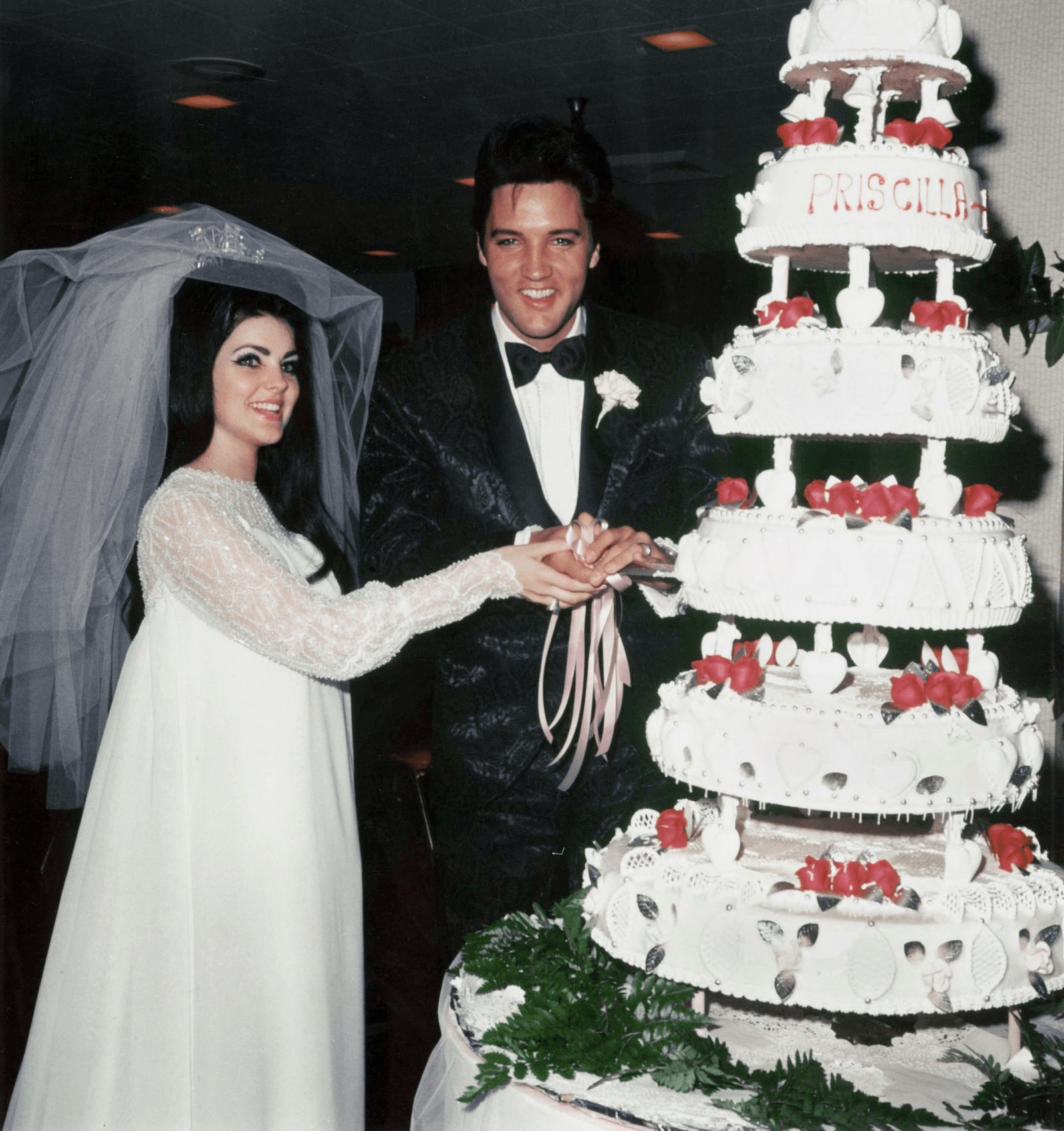 Elvis and Priscilla cutting the cake.